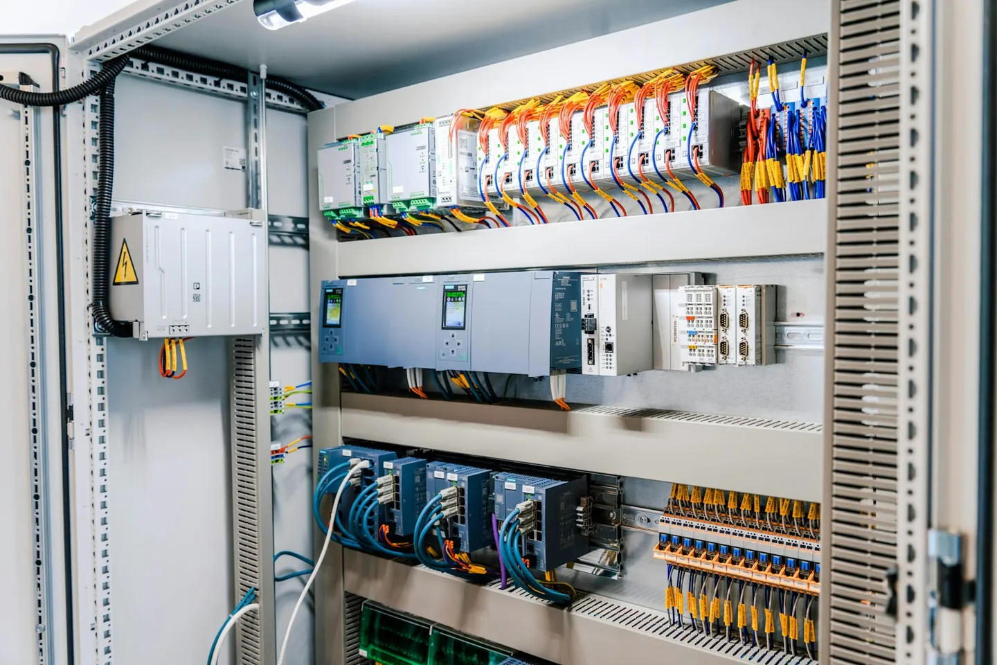 Et åbnet industrielt eltavleskab med ledninger og moduler, den type skab et analyselag læser data fra