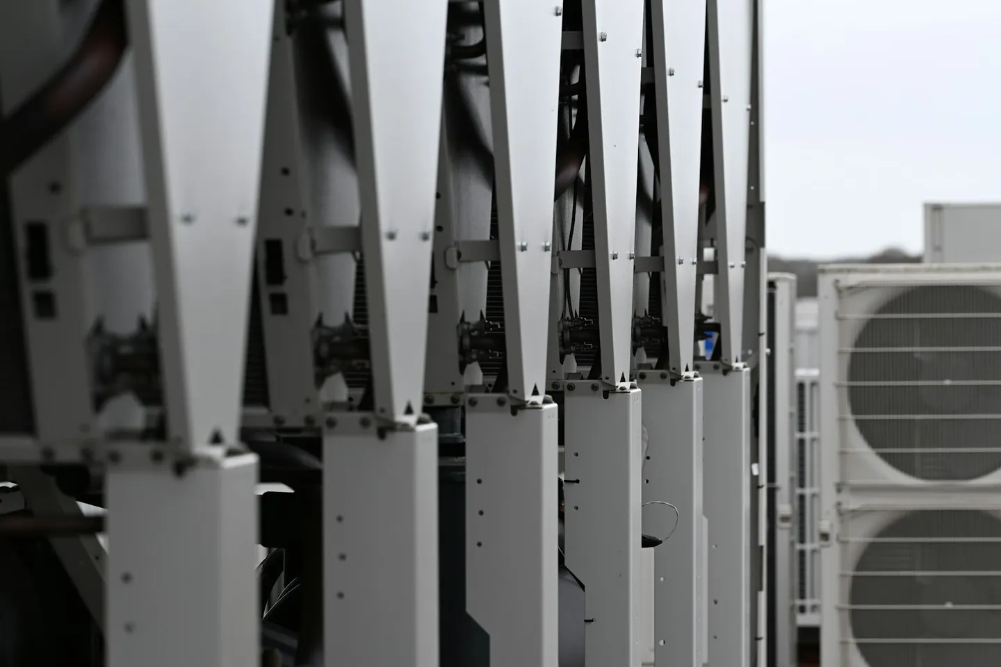 Row of white rooftop HVAC units on a commercial building, the kind of air plant Guideline 36 sequences target