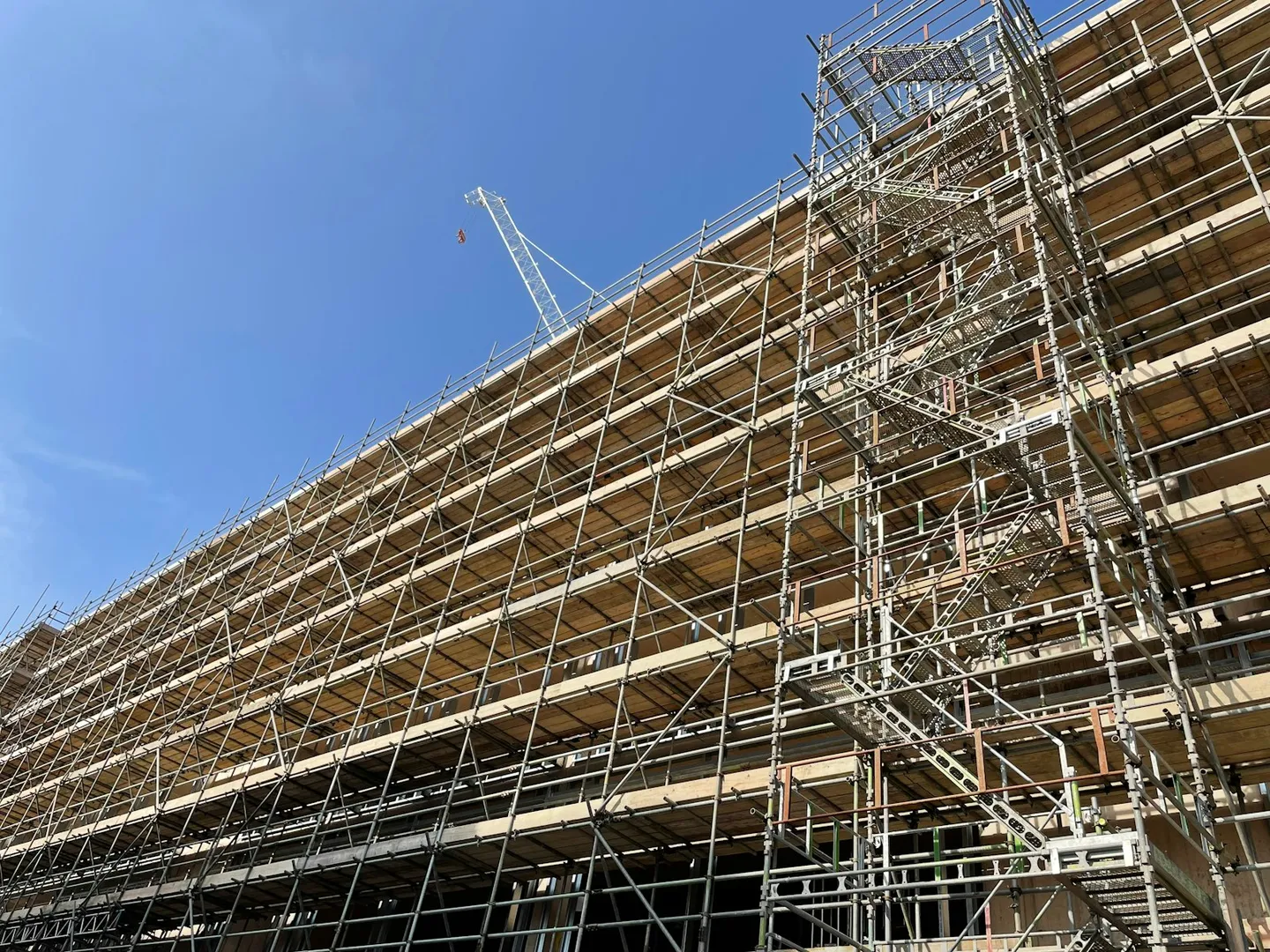 Tall commercial building wrapped in scaffolding during retrofit work
