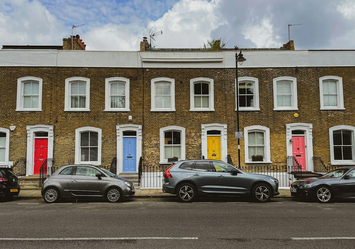 Terraced houses with cars parked along a residential UK street